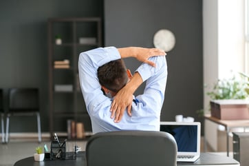 Man Stretching at Desk